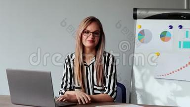 一幅美丽的欧洲女孩坐在办公室的<strong>笔记本</strong>电脑前的肖像，<strong>上面</strong>有一件白色衬衫，<strong>上面</strong>有图表和图片